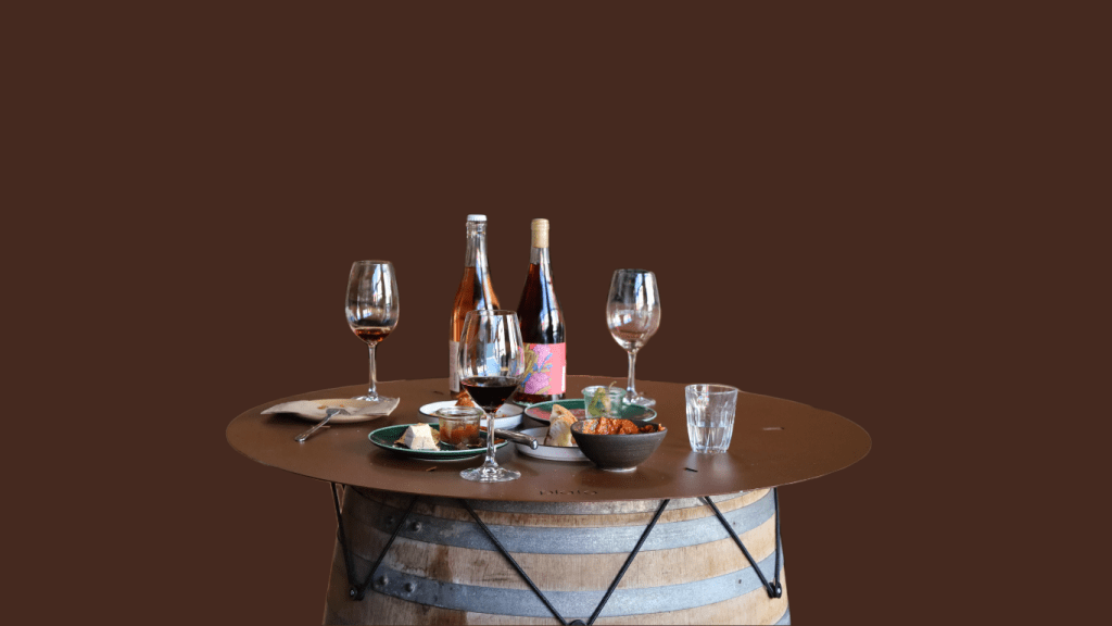 plato tabletop with burnt copper finish with wine, glasses and finger food